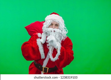 Santa asking for quiet with bag on green background