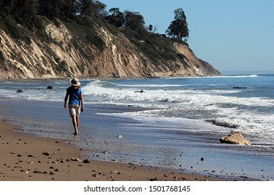 Santa Barbara, CA, Feb. 11, 2016: A Barefoot Beach Walker Enjoys The Ocean's Beauty.