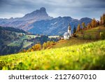 Santa Barbara church at the autumn Dolomite Alps. Amazing landscape with small chapel on sunny meadow at San Genesio village location, Province of Bolzano, South Tyrol, Italy