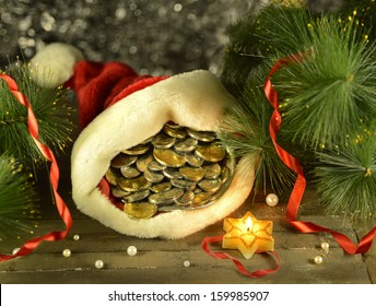 Santa cap with money and burning candle on blurred background