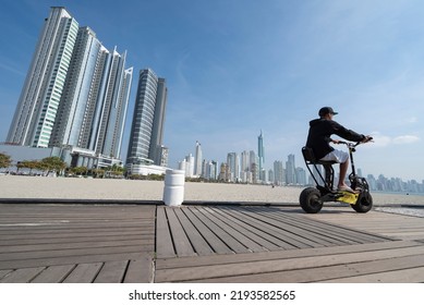 Balneário Camboriú, Santa Catarina, Brazil - July 28, 2022: Young Man Driving Kick Scooter Along The Pier Of Balneário Camboriú, Also Know As Brazilian Dubai.The City Has Elevated Quality Of Life.