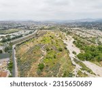 Santa Clarita, Valencia, California - June 10, 2023: aerial drone view toward empty land for a flood before the Santa Clara River between Valencia High School and Creekside Village