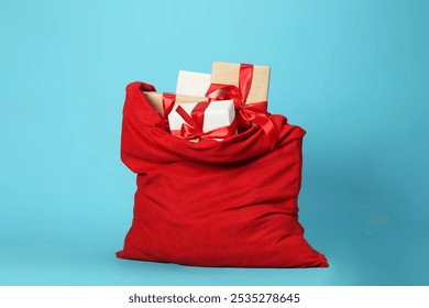 Santa Claus bag with gift boxes on light blue background - Powered by Shutterstock