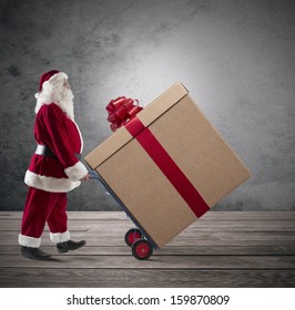 Santa Claus With Big Christmas Present In A Cart