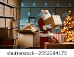 Santa Claus carrying delivery boxes in the warehouse on Christmas Eve