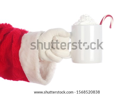 Santa Claus. Christmas Santa Arm. Isolated on white. Room for text. Santa Claus holds a cup of Hot Coco with a Candy Cane and Whip Cream. Santa Loves Hot Coco and Cookies on Christmas. 