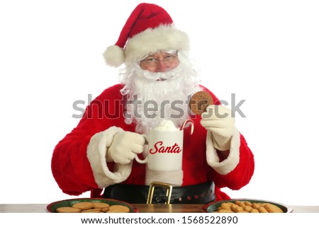 Santa Claus. Christmas Santa. Isolated on white. Room for text. Santa Claus holds a cup of Hot Coco with a Candy Cane and Whip Cream and Cookies. Santa Loves Hot Coco and Cookies on Christmas. 