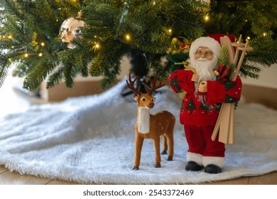 Santa Claus Doll under the Artificial Christmas tree with toy of deer and fake snow carpet. Christmas decoration ideas for home.  - Powered by Shutterstock