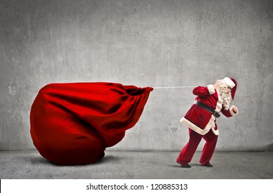 Santa Claus dragging his very large full of presents - Powered by Shutterstock