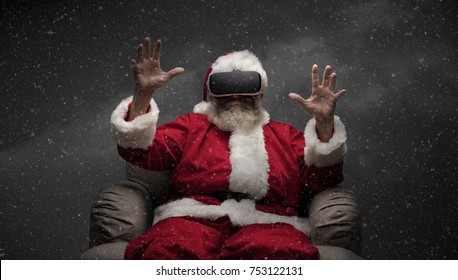Santa Claus experiencing virtual reality, he is wearing VR glasses and interacting with a virtual environment - Powered by Shutterstock