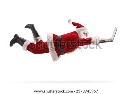 Santa claus flaying and using a laptop computer isolated on white background