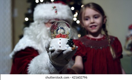 Santa Claus in front of a christmas tree in living room - Powered by Shutterstock