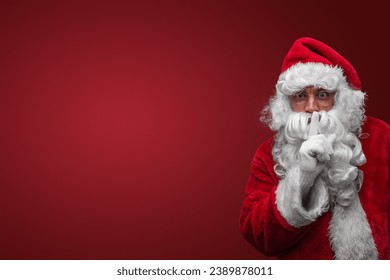 Santa Claus gesturing silence with finger on lips, mysterious holiday secret concept - Powered by Shutterstock