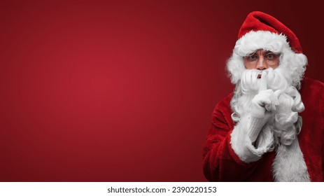 Santa Claus gesturing silence with finger on lips, mysterious holiday secret concept - Powered by Shutterstock