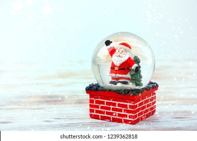 Santa Claus in glass ball on wooden table background. symbol of new year and Christmas holidays. festive winter season. template for design. copy space