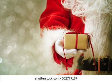 Santa Claus gloved hands holding giftbox - Powered by Shutterstock