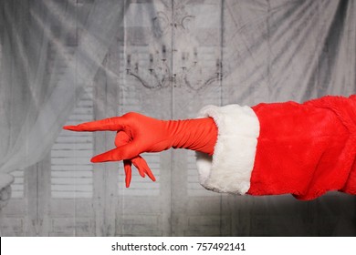 Santa Claus Or Grinch Hand In A Red Glove And Santa Arm.