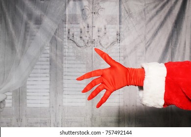 Santa Claus Or Grinch Hand In A Red Glove And Santa Arm.