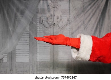 Santa Claus Or Grinch Hand In A Red Glove And Santa Arm.