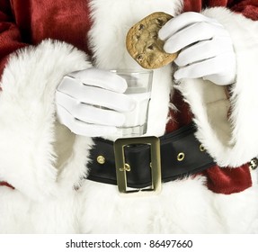 Santa Claus Hand Holding Milk With A Chocolate Chip Cookie