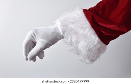 Santa claus hand with white glove and red traditional costume making gesture of catching something with white gradient background. - Powered by Shutterstock