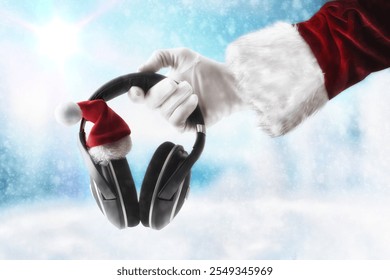 Santa Claus hands holding headphones to listen to Christmas music decorated with Santa hat and snowy landscape background. - Powered by Shutterstock