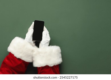 Santa Claus hands with modern mobile phone on color background, closeup - Powered by Shutterstock