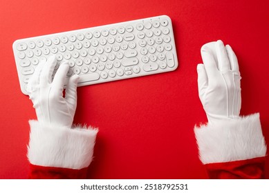 Santa Claus hands typing on a white keyboard, symbolizing Christmas and digital communication. Ideal for festive, holiday, and technology themes - Powered by Shutterstock