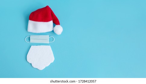 Santa Claus Hat And Beard With Face Mask On A Blue Background, Creative Minimal Concept Of Christmas And New Year