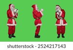 Santa claus having fun with videogames, playing online gaming competition and standing over full body greenscreen. Young cool saint nick character play mobile game on christmas eve.