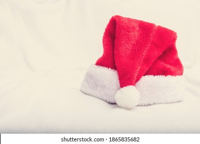 Santa Claus Headdress, Red Santa Hat, Closeup, White Crumpled Blanket, Copy Space, Side View, Toned