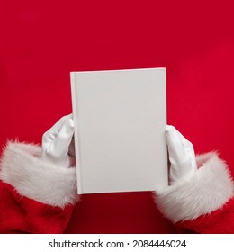 Santa Claus Holding A Book With Blank Pages. Christmas Book Mockup