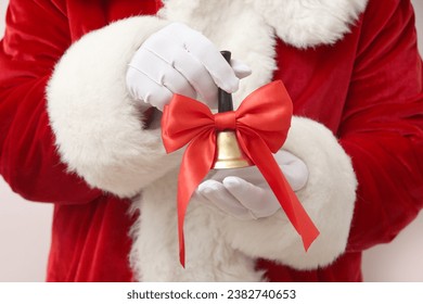 Santa Claus holding Christmas bell with red bow on white background - Powered by Shutterstock