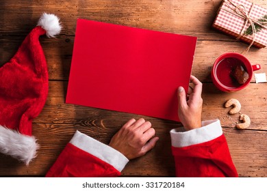 Santa Claus Holding An Empty Wish List In His Hands