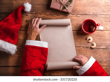 Santa Claus Holding An Empty Wish List In His Hands