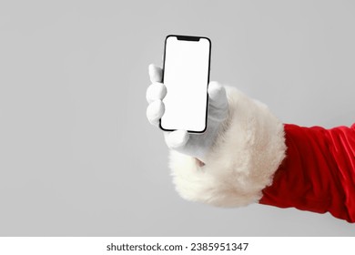 Santa Claus holding mobile phone with blank screen on grey background - Powered by Shutterstock