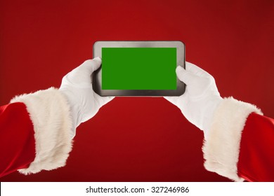 Santa Claus is holding a plate with a green background. Red background. - Powered by Shutterstock