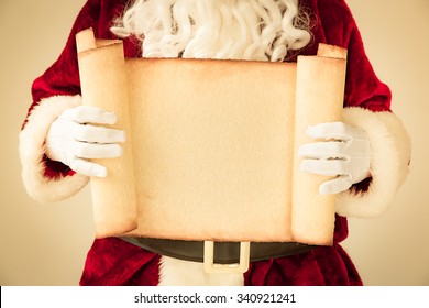 Santa Claus holding scroll paper blank in hands. Christmas holiday concept