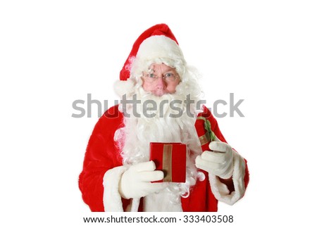 Santa Claus holds a Red Velvet Christmas Present filled with an unknown surprise for someone for Christmas this year. You decide what is inside. Isolated on white with room for your text. 