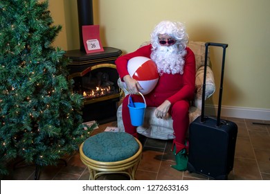 Santa Claus In House Packed With Beach Toys For Holiday Wearing Red Long Johns  The Day After Christmas.