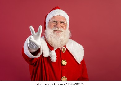 Santa Claus Looking At The Camera. Christmas Is Coming. Merry Christmas. Peace. V Sign.