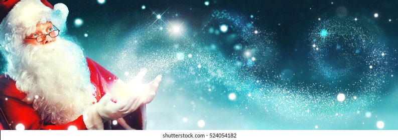 Santa Claus with magic gift in his hands. Portrait of happy Santa Claus making magic at night, Blowing Magic Christmas Stars
