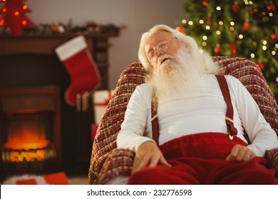 Santa claus napping on the armchair at home in the living room - Powered by Shutterstock