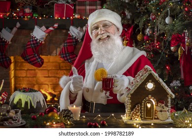 Santa Claus near fireplace and Christmas tree. Festive interior inside wooden house, New Year's cheerful mood Spirit of Christmas. Senior man with real white beard cosplay Father Christmas. - Powered by Shutterstock