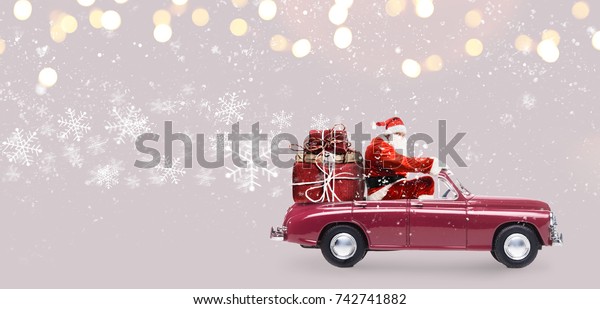 Santa Claus on car delivering Christmas or New\
Year gifts at snowy gray\
background