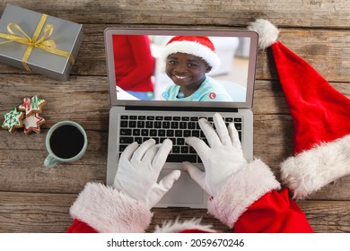 Santa claus on christmas laptop video call with african american boy. christmas, festivity and communication technology.