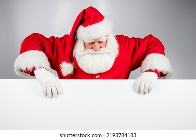 Santa Claus peeks out from behind an ad on a white background. Merry Christmas. - Powered by Shutterstock