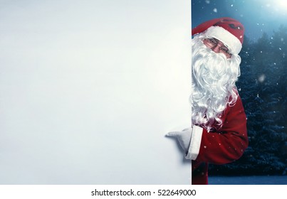 Santa Claus pointing on blank white wall, advertisement banner with copy space - Powered by Shutterstock