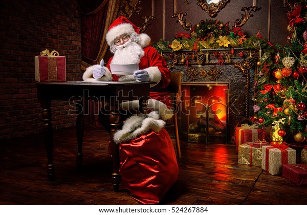 サンタクロースはクリスマスの準備をしていて 子どもの手紙を読んでいます サンタクロースの郵便 クリスマスの飾り の写真素材 今すぐ編集