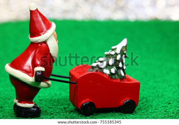 santa claus push cart\
of christmas tree